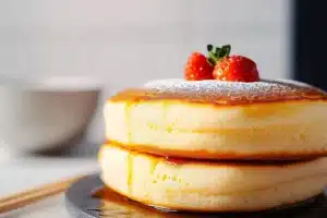 Stack of fluffy Japanese soufflé pancakes with powdered sugar