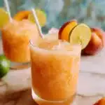 Peach Agua Fresca in a glass with fresh fruit garnish